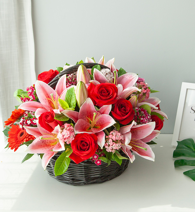 Basket of pink lilies and red roses